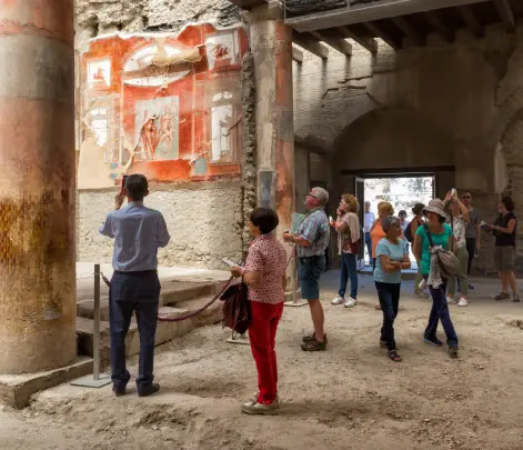 tourists viewing frescoes in herculaneum